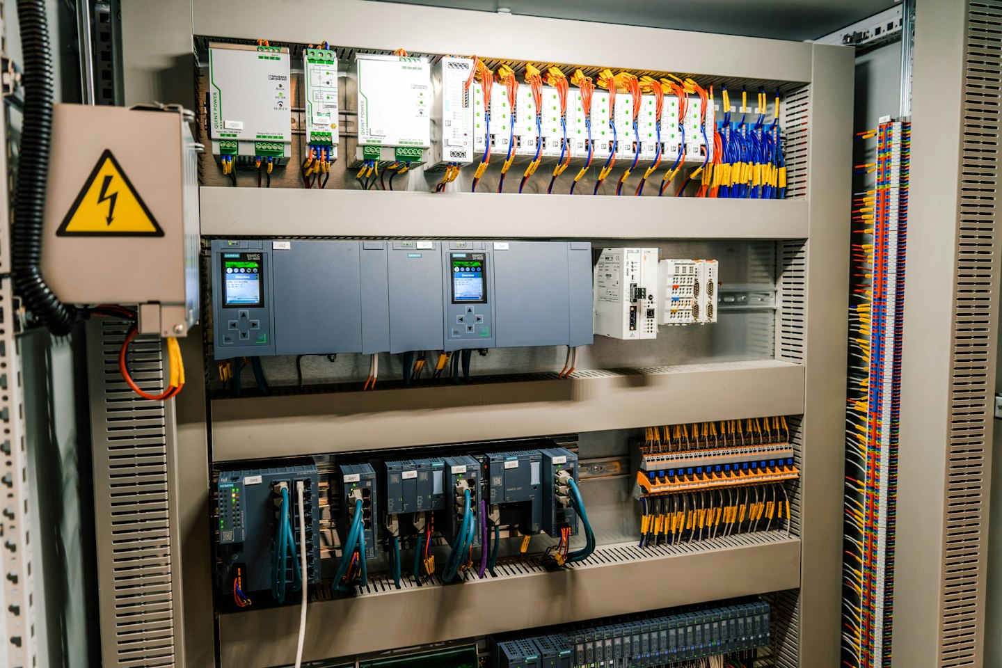 Open elektrische schakelkast vol met complexe bedrading en componenten.